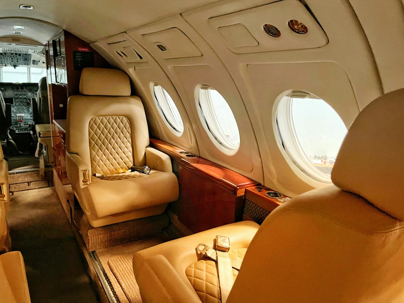Sunlight falling across tan leather seats in a private aircraft cabin